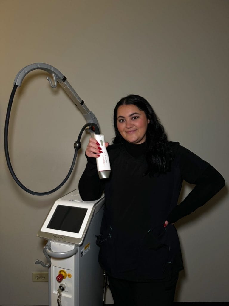 Employee Weronika holding the Lutronic Infini microneedling laser