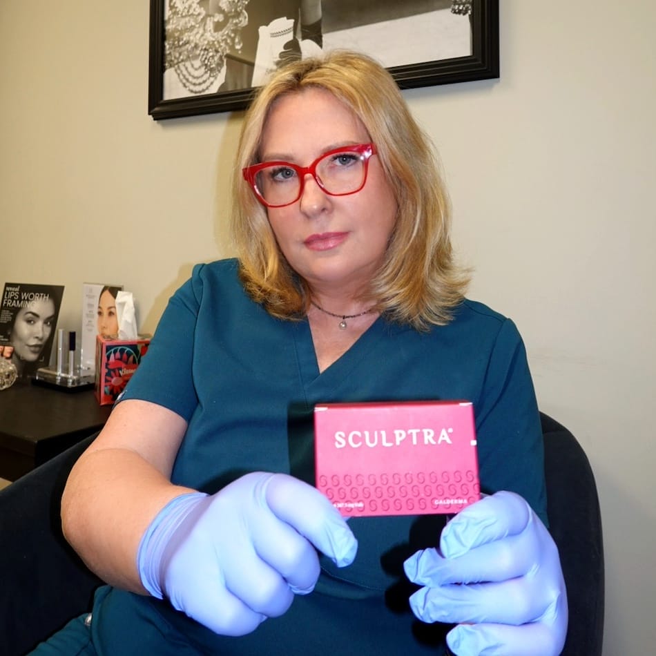 Dr. Pecherek holding a box of the Sculptra Wrinkle Relaxer